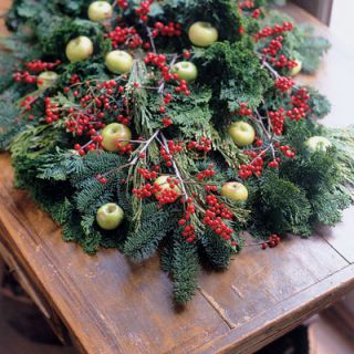 Boughs and berries announce the season. When creating a swag, the trick lies in layering. Starting with a carpet of dense evergreen, such as white fir, lay on something lighter, such as arborvitae or cedar, then contrast with swirling Chamaecyparis branches. Top with winterberry and lady's apples for a glorious statement.